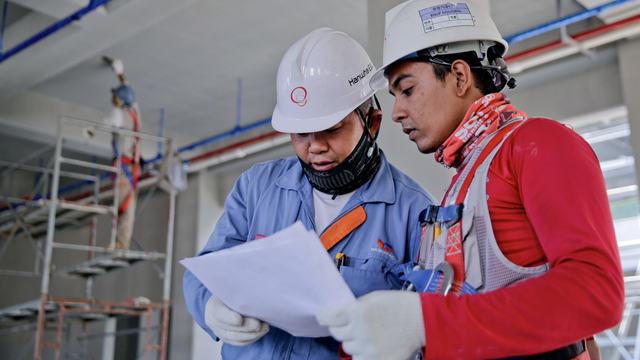Construction crew reviewing work on an active job site.