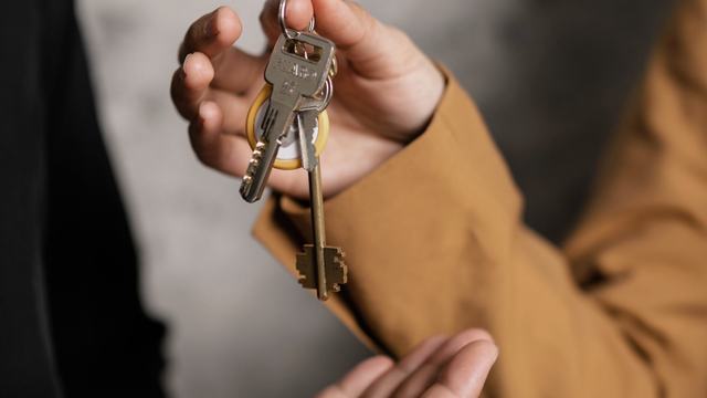 Keys to a managed rental unit resting on a leasing agreement.