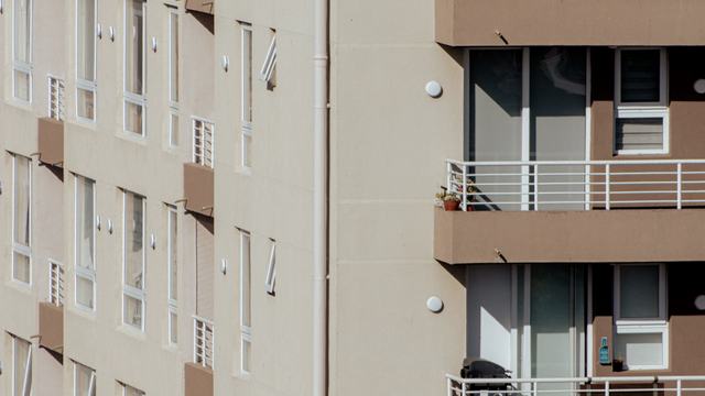 Facade of a modern low-rise apartment building with balconies.